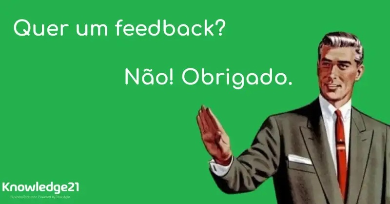 O título do texto como se fosse alguém dialogand com o meme de um homem com a mão estendida fazendo o sinal de pare. A pessoa que não aparece na imagem pergunta: Quer um feedback? O homem responde: Não! Obrigado. O Logo da K21 aparece no canto esquerdo
